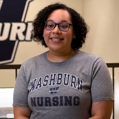 Monica West smiles while wearing a shirt that says Washburn